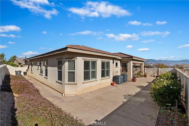 view of side of property featuring central AC, a patio area, and a mountain view