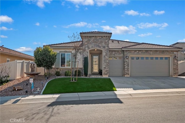 mediterranean / spanish house featuring a garage and a front yard