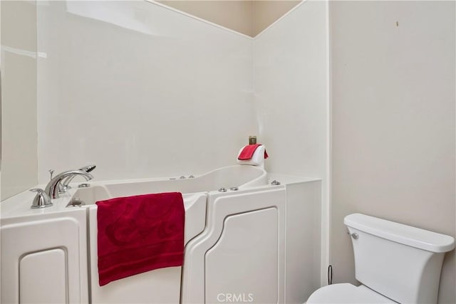 bathroom featuring toilet and a tub