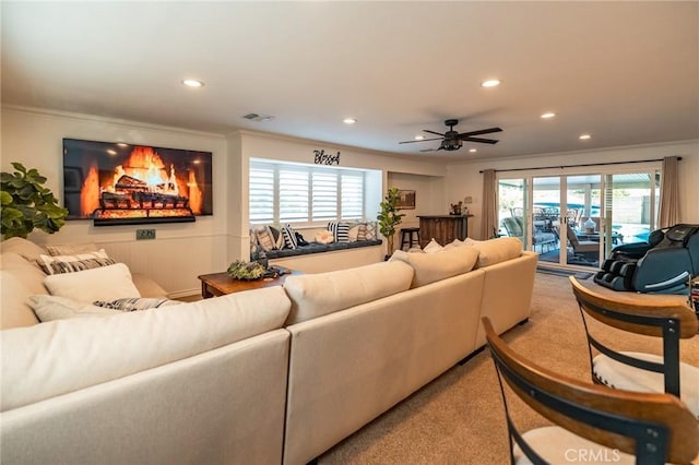 living room featuring ceiling fan, a wealth of natural light, and crown molding