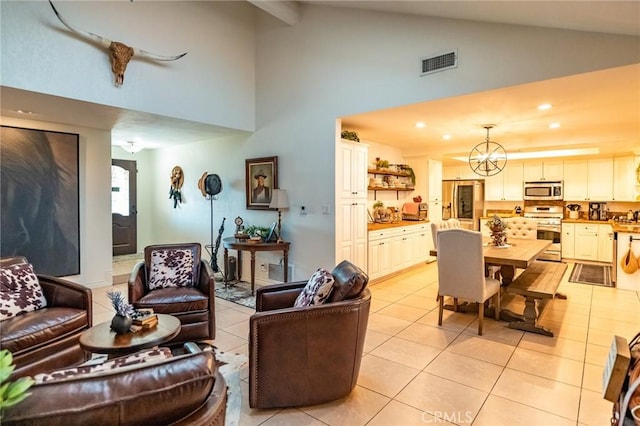 tiled living room featuring high vaulted ceiling and a notable chandelier