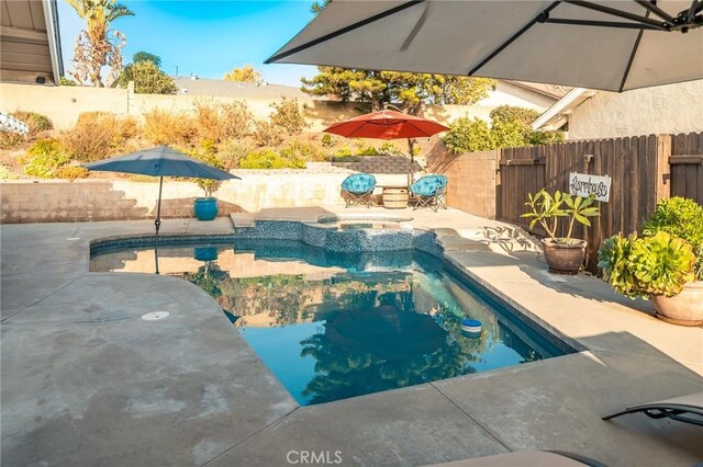 view of swimming pool featuring a patio area and an in ground hot tub