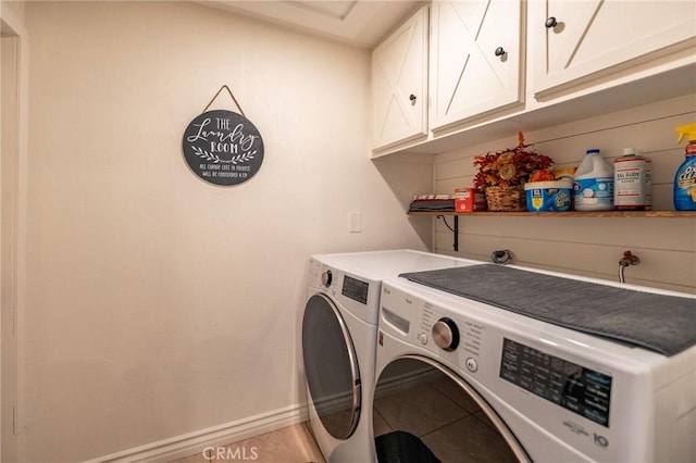 washroom with light tile patterned floors, independent washer and dryer, and cabinets