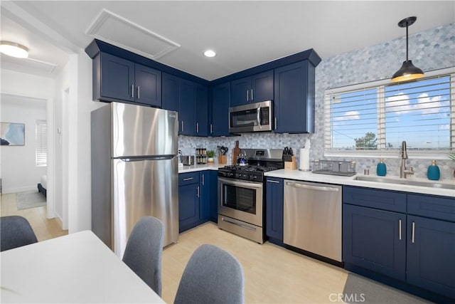 kitchen with blue cabinets, sink, stainless steel appliances, and pendant lighting