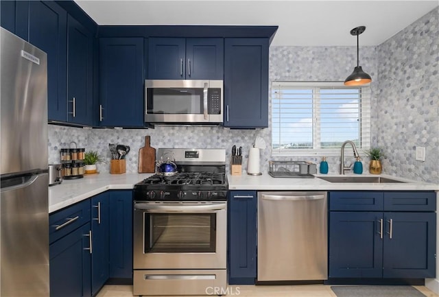 kitchen featuring appliances with stainless steel finishes, decorative backsplash, blue cabinets, and sink