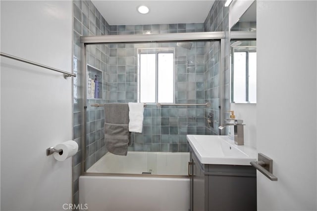 bathroom featuring a wealth of natural light, shower / bath combination with glass door, and vanity