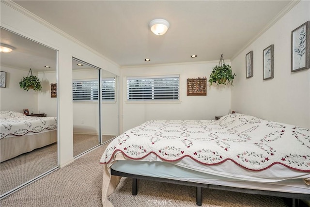 carpeted bedroom featuring crown molding and two closets