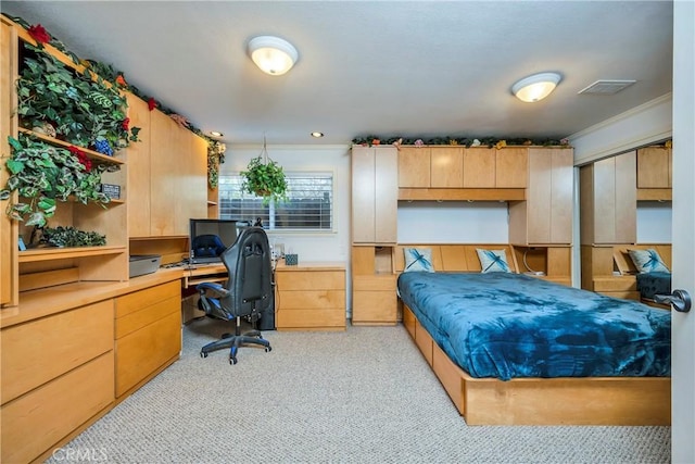 bedroom featuring built in desk and light colored carpet