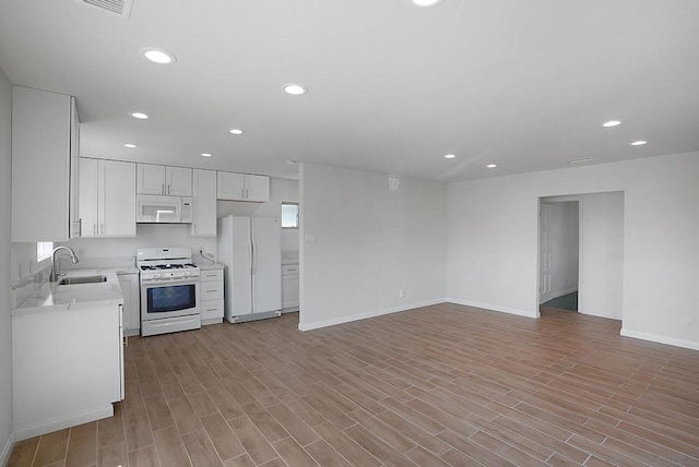 kitchen with light hardwood / wood-style floors, sink, white appliances, and white cabinets