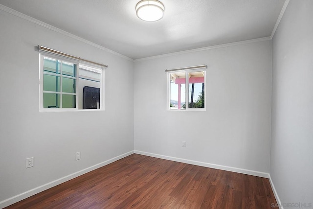 spare room featuring dark hardwood / wood-style flooring and crown molding