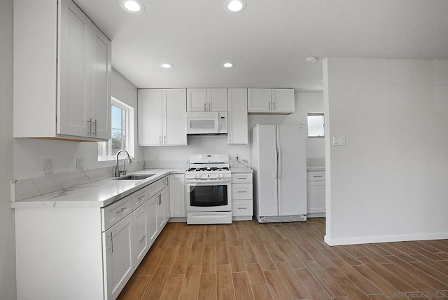 kitchen with white cabinets, sink, and white appliances