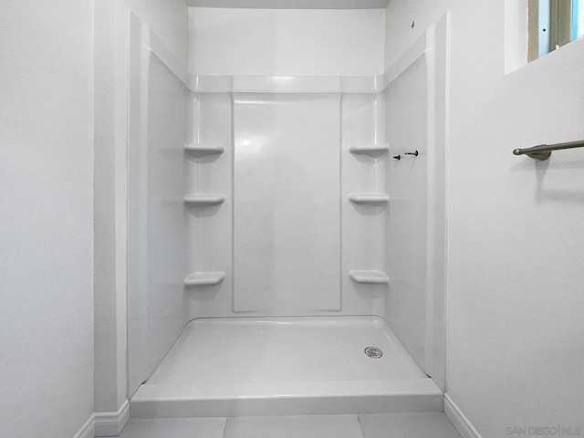 bathroom with a shower and tile patterned floors