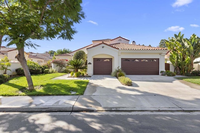 mediterranean / spanish-style home featuring a front lawn and a garage