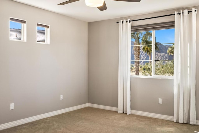 carpeted empty room featuring ceiling fan and a wealth of natural light