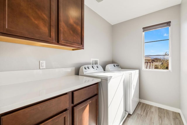 laundry room featuring cabinets, independent washer and dryer, and light wood-type flooring