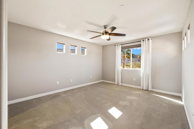 spare room featuring carpet, a healthy amount of sunlight, and ceiling fan