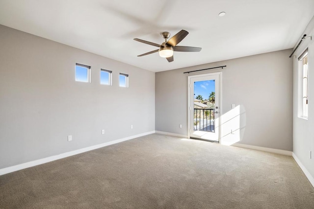 unfurnished room featuring a healthy amount of sunlight, ceiling fan, and carpet flooring