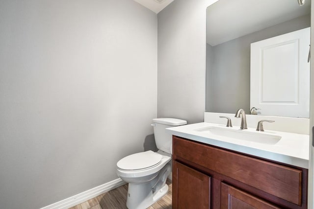 bathroom with vanity, toilet, and wood-type flooring