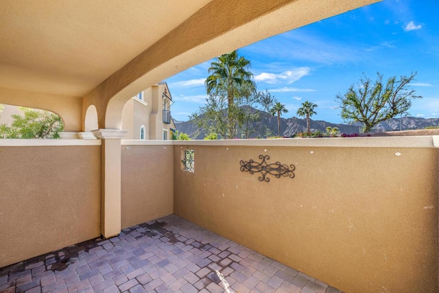 view of patio featuring a mountain view and a balcony