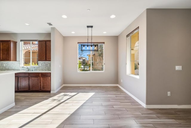 kitchen with hanging light fixtures, sink, and decorative backsplash