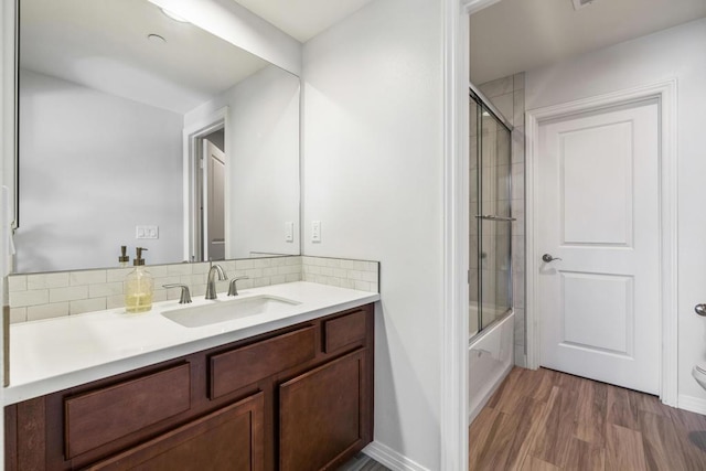 bathroom featuring vanity, wood-type flooring, and shower / bath combination with glass door