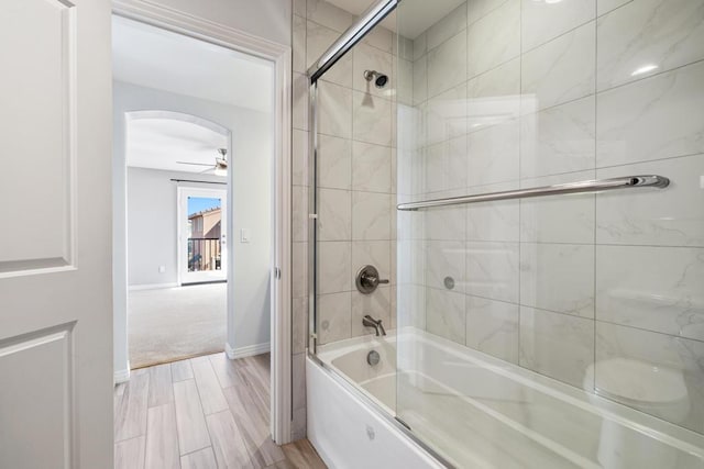 bathroom with ceiling fan and bath / shower combo with glass door