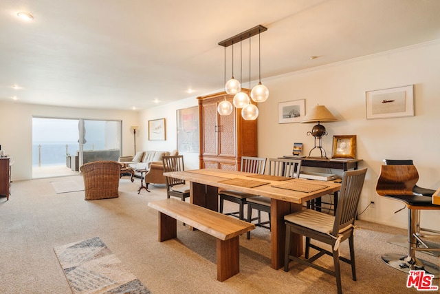 dining room with crown molding and light colored carpet