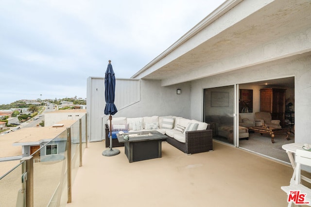 view of patio with an outdoor living space with a fire pit