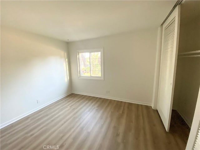 unfurnished bedroom featuring hardwood / wood-style floors and a closet