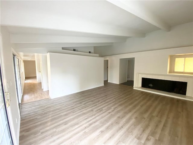 unfurnished living room with lofted ceiling with beams and hardwood / wood-style flooring