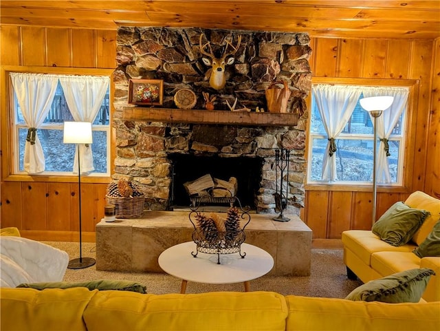 living room featuring wooden ceiling, carpet flooring, wood walls, and a fireplace