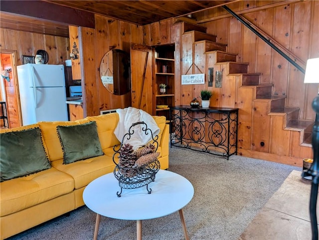 carpeted living room featuring wood ceiling and wooden walls