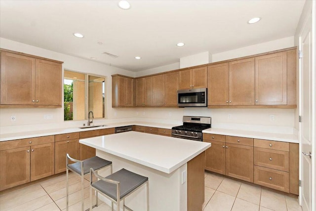 kitchen featuring a center island, sink, a breakfast bar area, stainless steel appliances, and light tile patterned floors