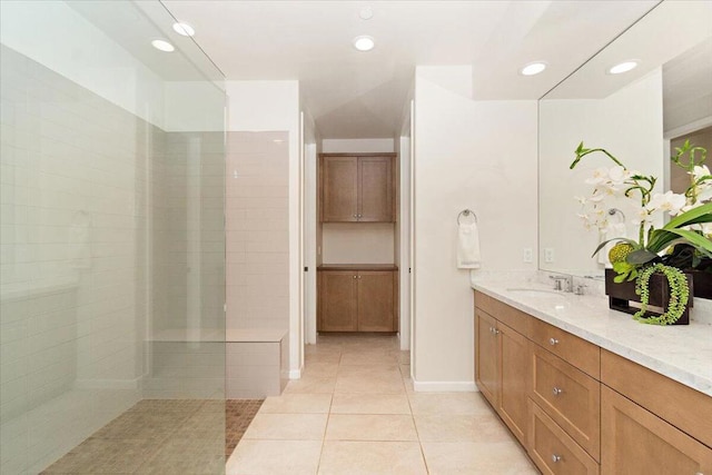 bathroom with tile patterned floors, vanity, and tiled shower