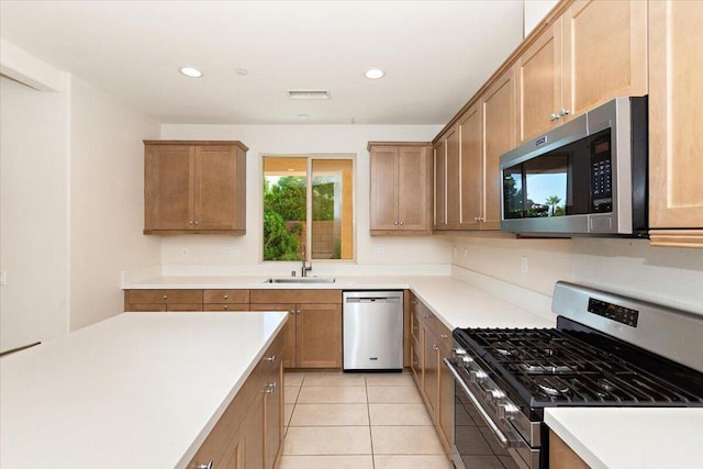 kitchen with light tile patterned floors, sink, and stainless steel appliances