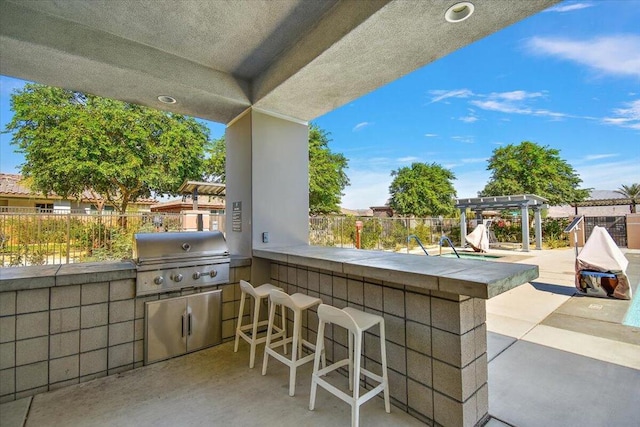 view of patio / terrace featuring an outdoor bar, a pergola, and grilling area