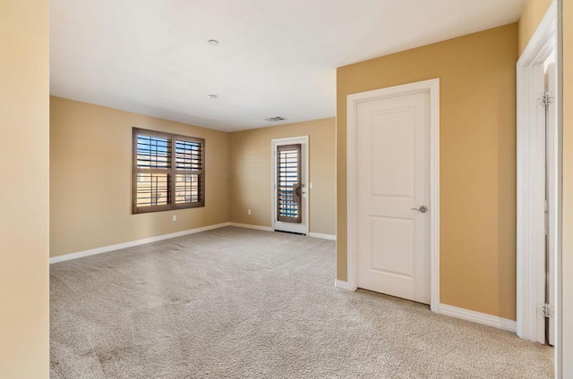 spare room featuring light colored carpet