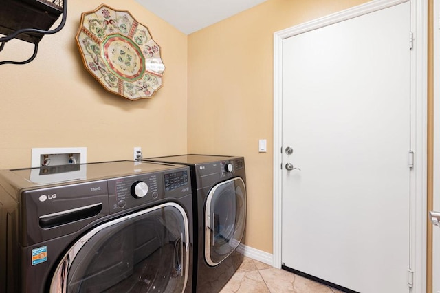 laundry area with light tile patterned floors and washing machine and clothes dryer