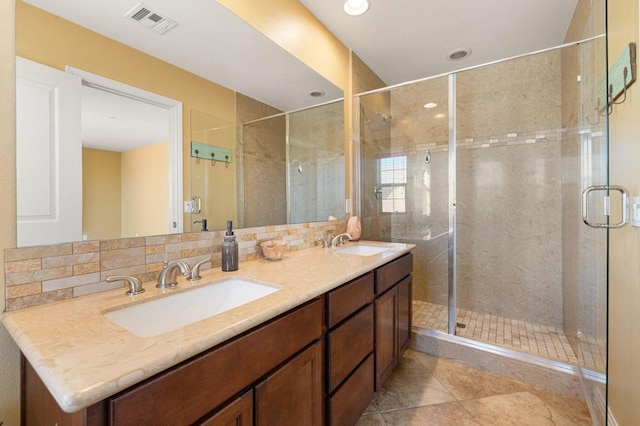 bathroom with vanity, tile patterned flooring, tasteful backsplash, and a shower with door