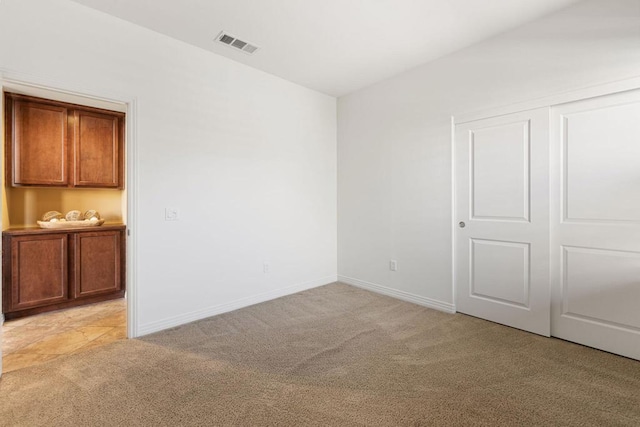 interior space featuring a closet and light carpet