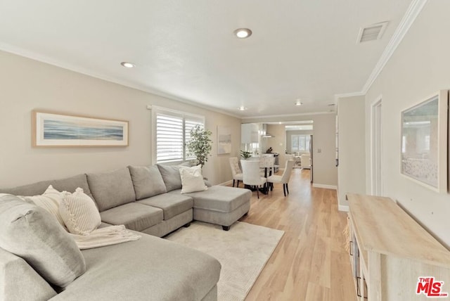 living room featuring crown molding and light hardwood / wood-style floors