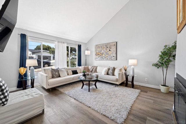 living room with high vaulted ceiling and hardwood / wood-style floors