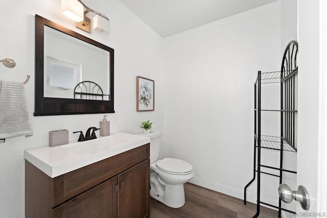 bathroom featuring toilet, vanity, and hardwood / wood-style floors