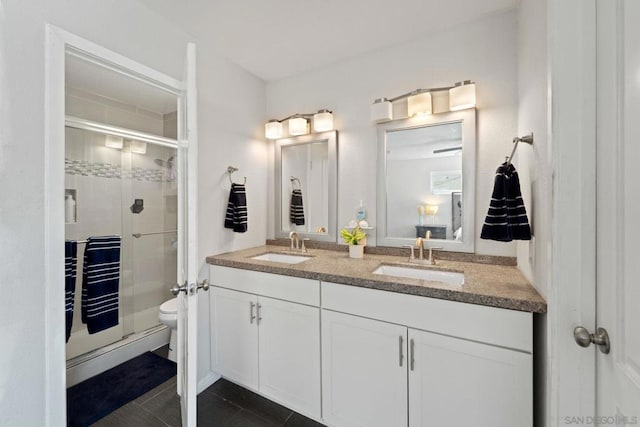 bathroom featuring toilet, tile patterned floors, walk in shower, and vanity