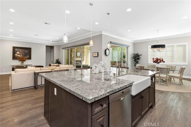 kitchen with a large island with sink, dishwasher, sink, hardwood / wood-style flooring, and hanging light fixtures