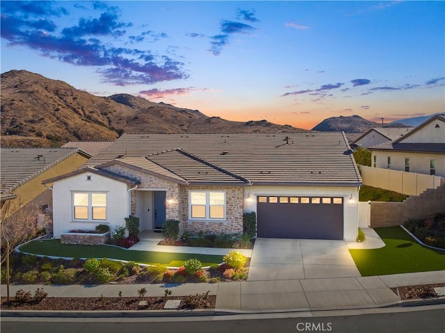 view of front of property featuring a mountain view, a yard, and a garage