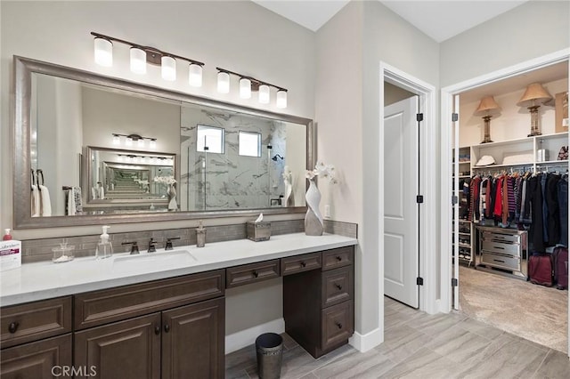 bathroom featuring a shower and vanity