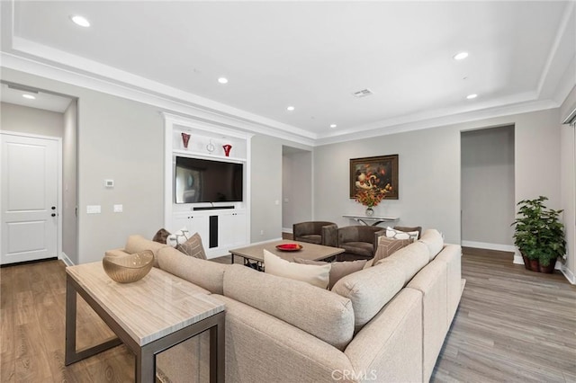 living room featuring built in features and light hardwood / wood-style flooring