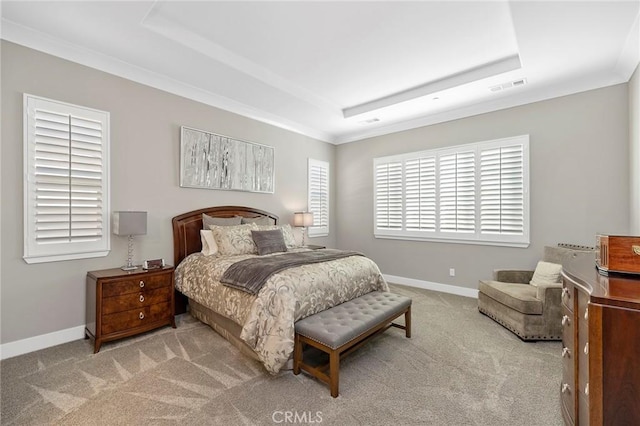 carpeted bedroom with ornamental molding and a raised ceiling