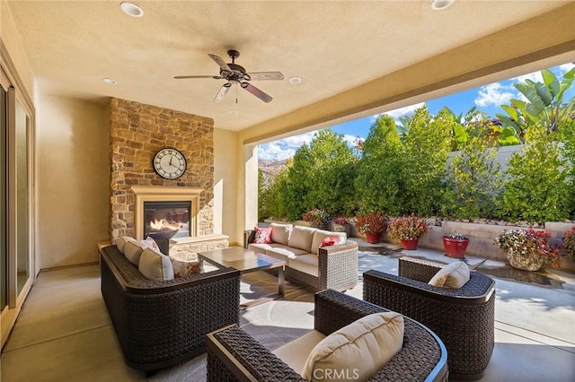 view of patio featuring ceiling fan and an outdoor living space with a fireplace